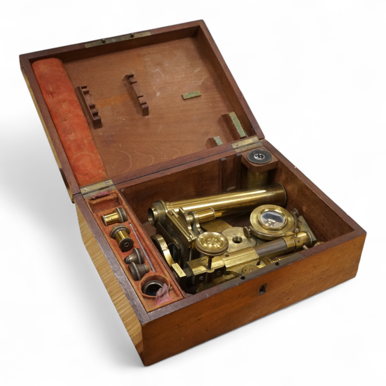 A mahogany cased 19th century brass field microscope, the body separates into sections, in a fitted case together with a selection of alternative lenses and other accessories, the microscope is unsigned, when closed the